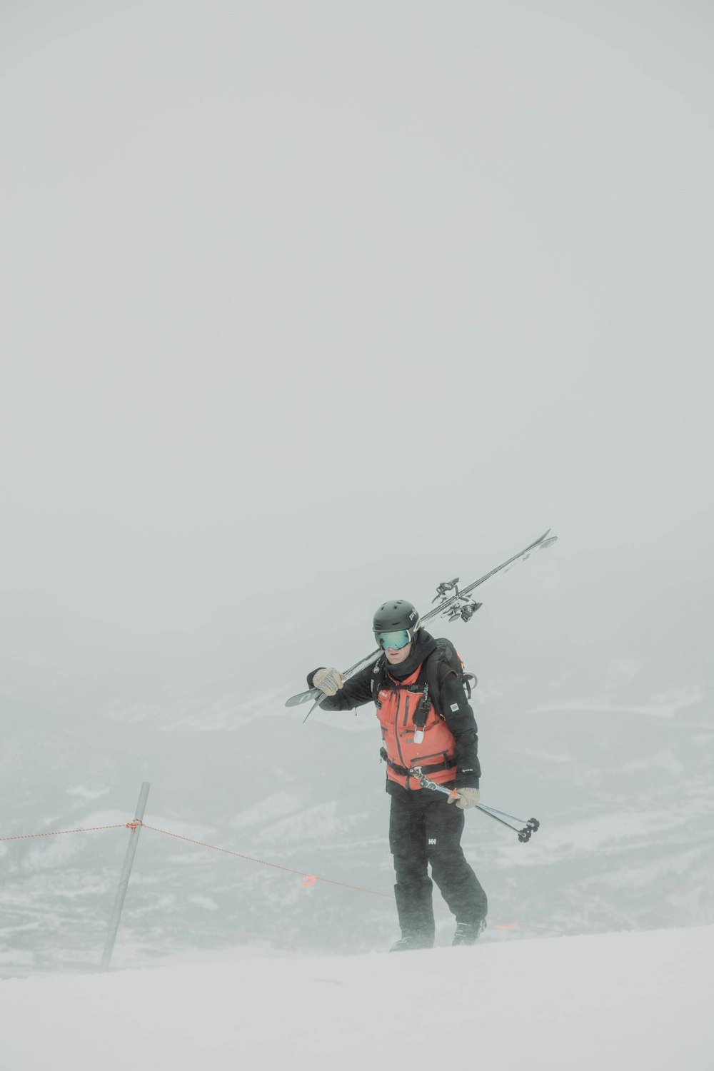 Un hombre parado en la cima de una ladera cubierta de nieve