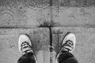 Black and white photo of stylish urban sneakers on a concrete city street.