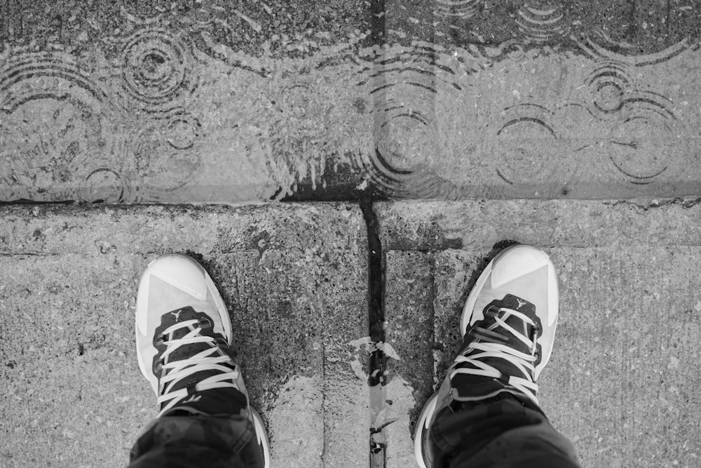 uma pessoa em pé em uma calçada com os pés para cima