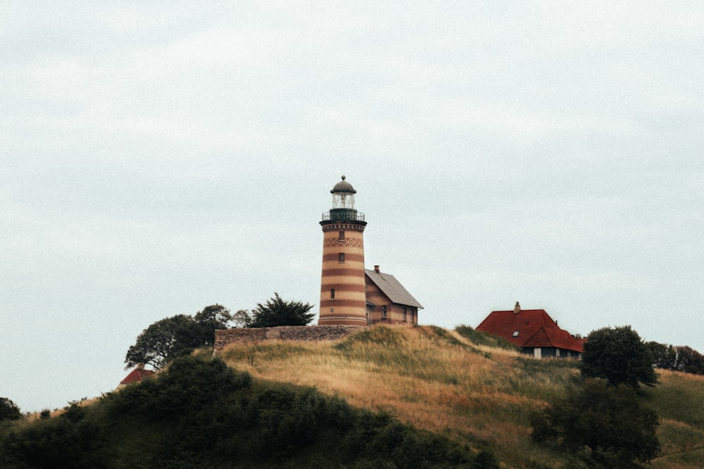 a lighthouse on top of a hill with trees