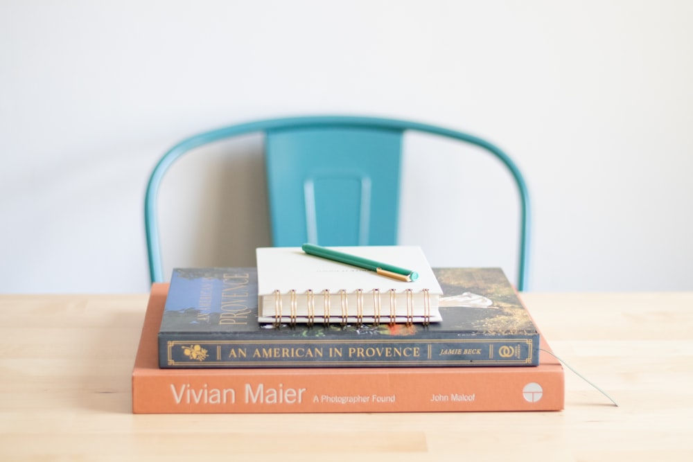 나무 탁자 위에 놓여 있는 책 더미