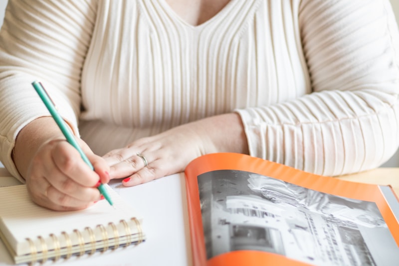 Senior woman writing in a journal at a desk with a pen, practicing daily reflection and memory journaling