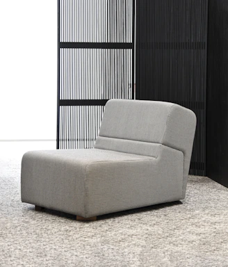 A sleek, modern armchair with clean lines and light gray fabric, perfect for contemporary spaces.