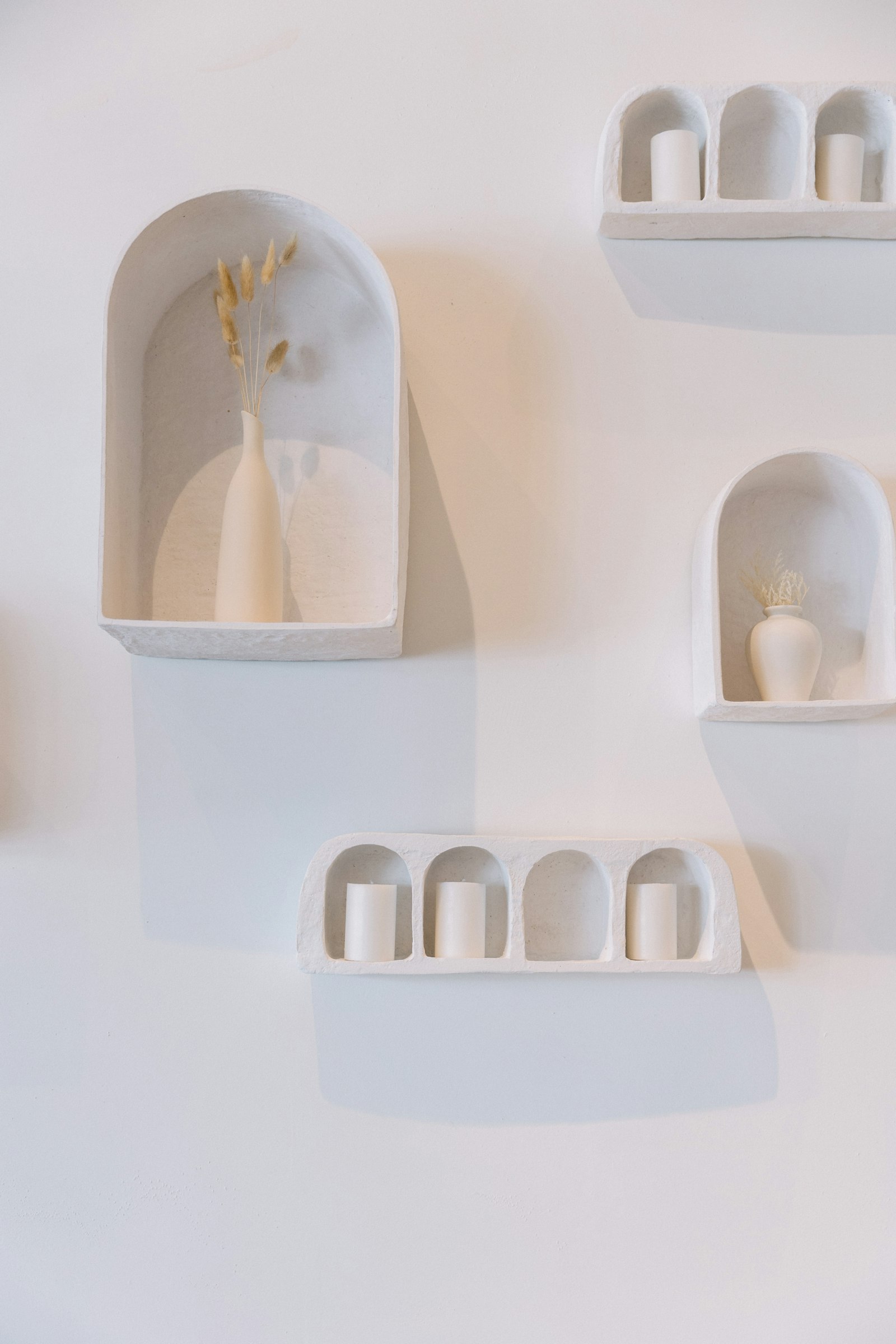 White arched wall niches styled with a few white vases