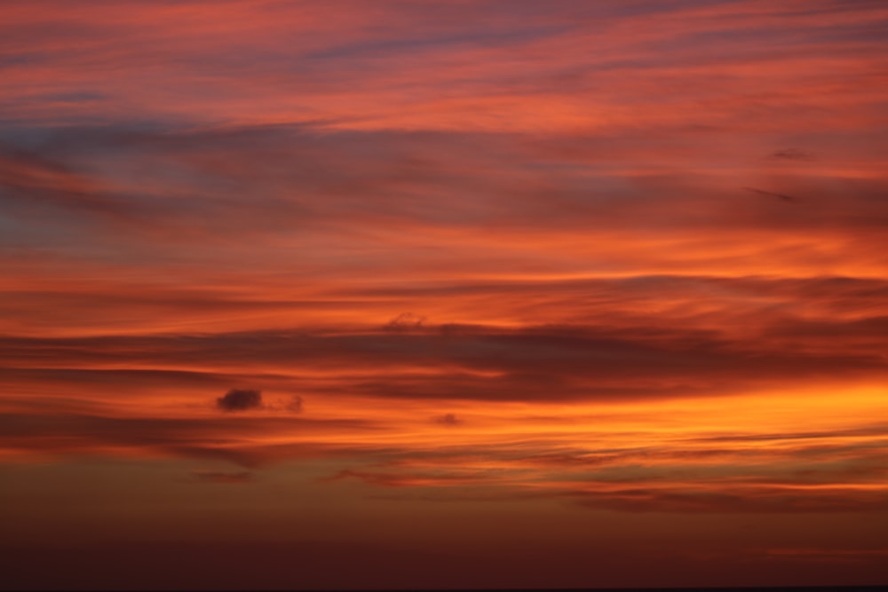 a red and orange sunset over the ocean