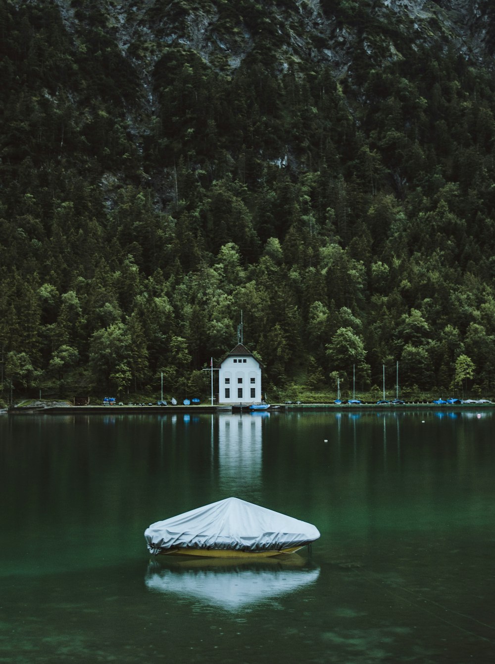 a boat floating on top of a lake next to a forest