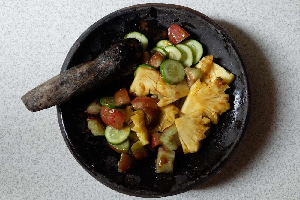 a plate of food with cucumbers, tomatoes, and other vegetables