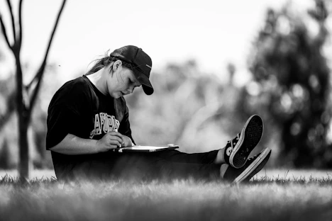 A person writing in a journal with a peaceful nature background.