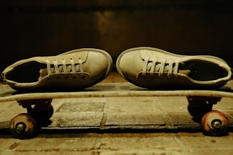 Sneakers resting on a skateboard with graffiti walls in the background.
