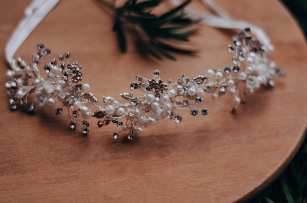 Delicate baby headbands with floral details displayed on a rustic wooden table