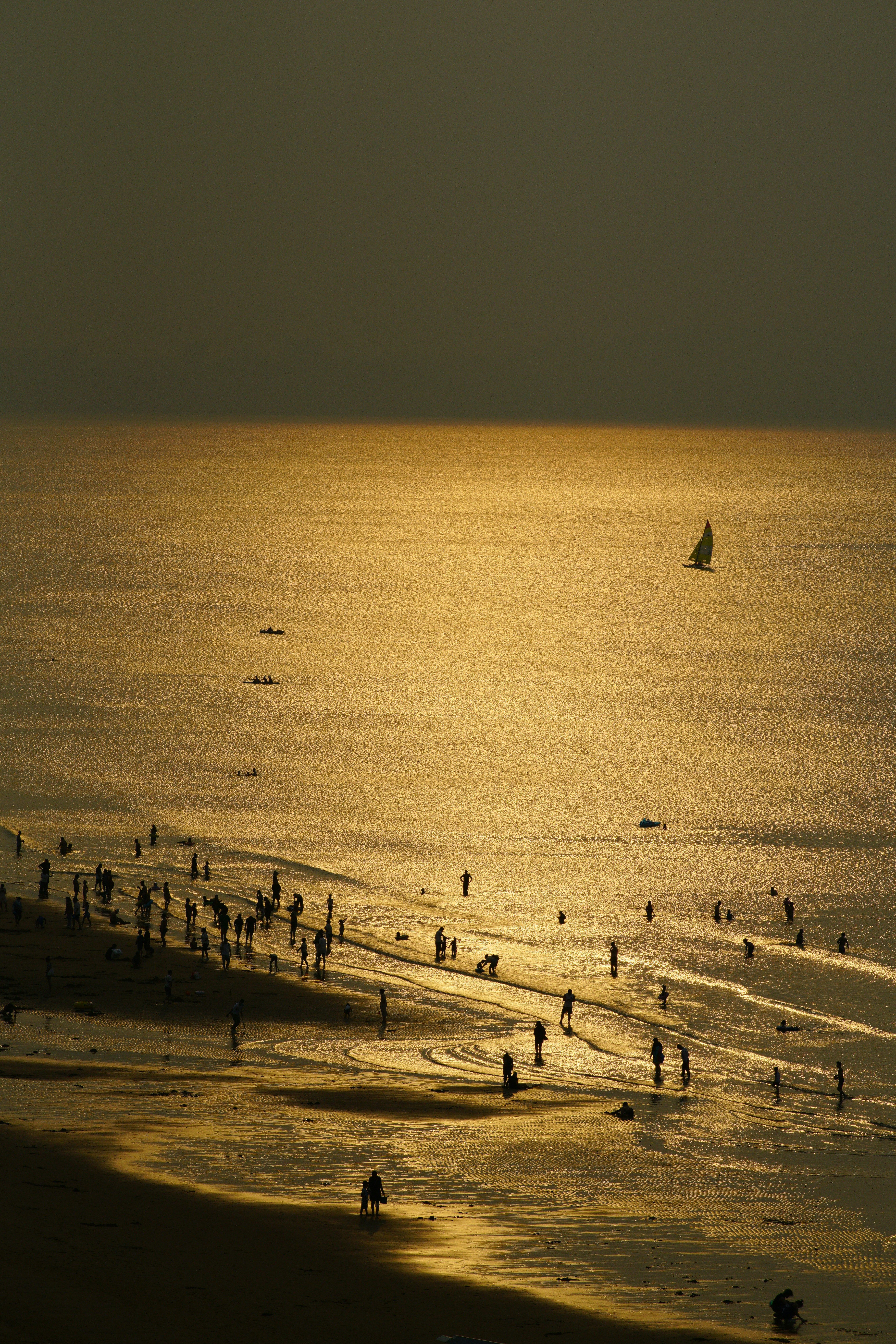 a group of people standing on top of a beach next to the ocean