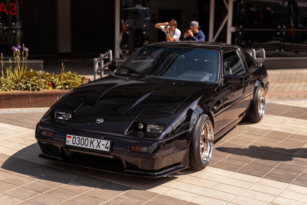 a black sports car parked in front of a building