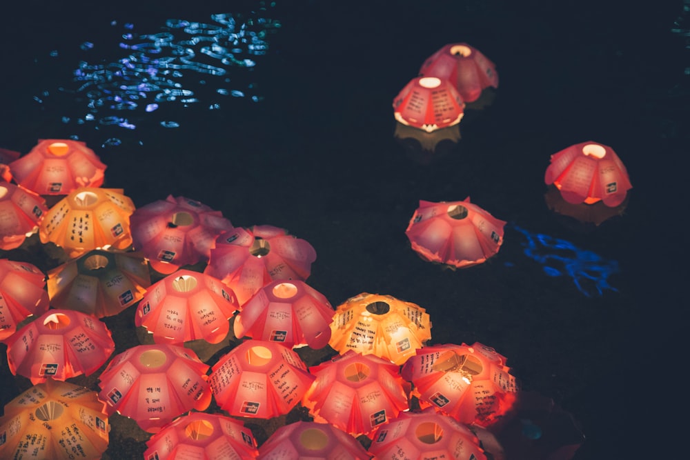 a group of red and yellow lanterns floating on top of water