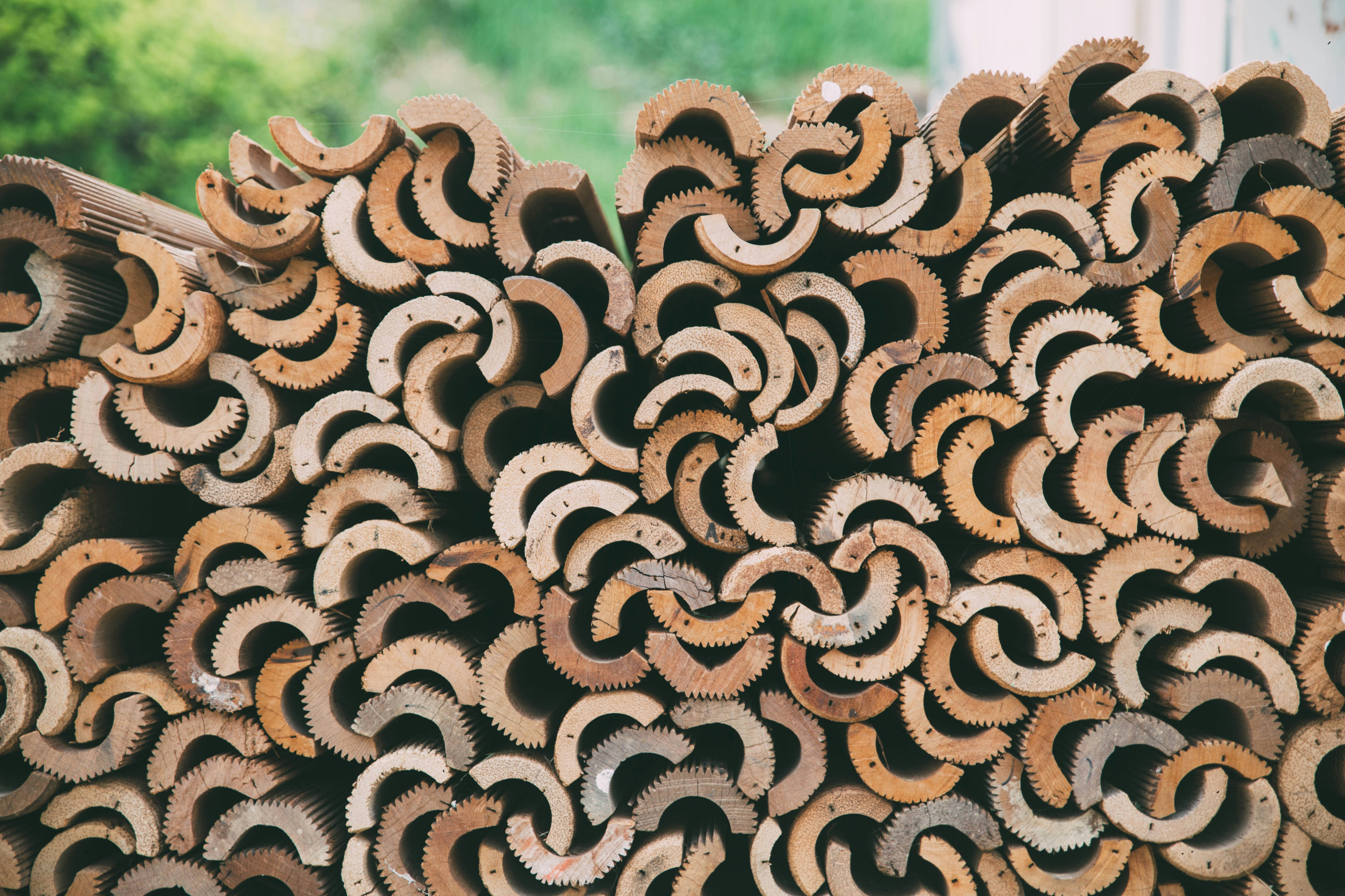 a large pile of wooden pipes stacked on top of each other