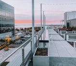 Outdoor patio with stylish seating and city skyline view at sunset.