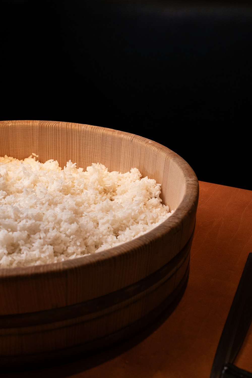 a wooden bowl filled with rice on top of a table