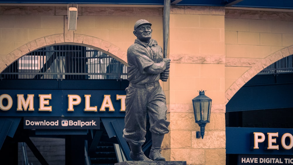 Una estatua de un jugador de béisbol frente a un edificio