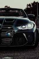 High-contrast image of a sports car’s front grille and headlights gleaming after ceramic coating.