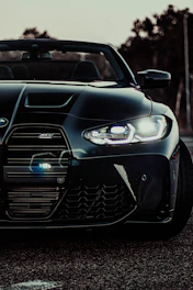 Close-up shot of a matte black supercar’s aggressive front grille under moody lighting.