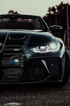 Close-up shot of a matte black supercar’s aggressive front grille under moody lighting.
