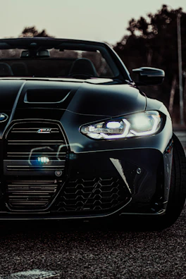 High-contrast image of a sports car’s aggressive front grille and headlights.
