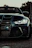 Close-up of a sleek sports car grill gleaming under city lights at night.