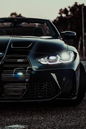 Close-up shot of a sleek supercar's front grille with metallic silver accents under moody lighting.