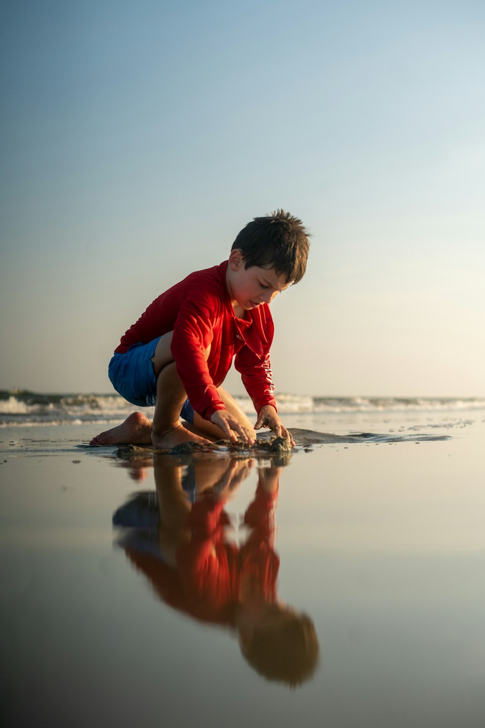 Ein kleiner Junge spielt am Strand