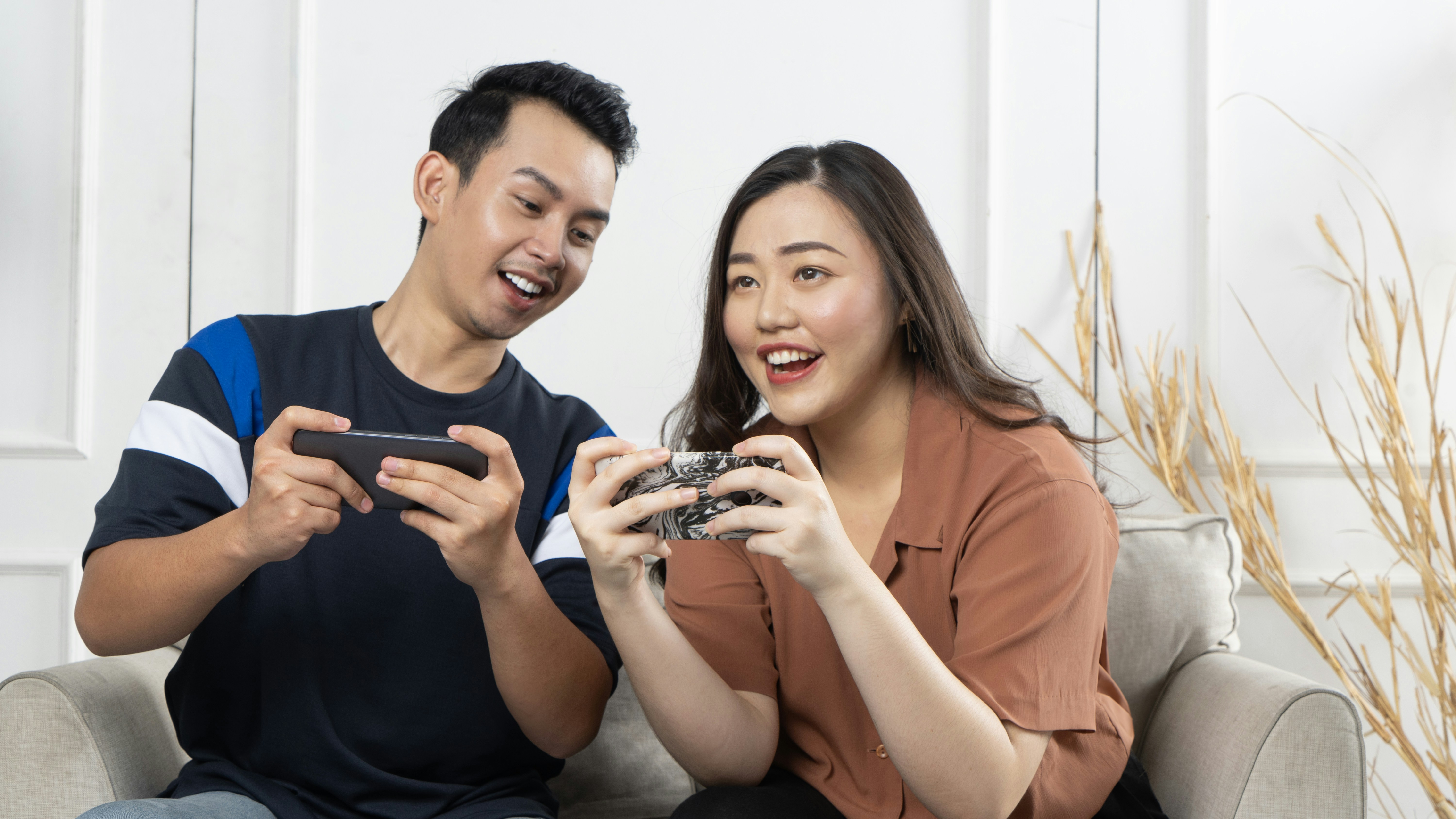 Cute couple playing games on mobile phones together