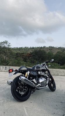 A red cruiser motorbike with chrome details against a mountain backdrop.