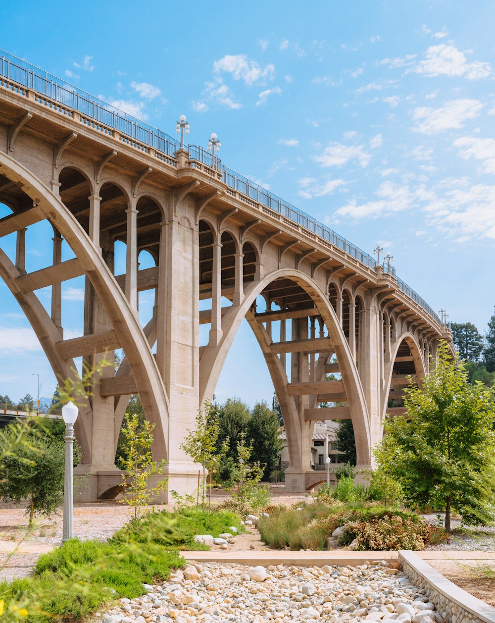 a large bridge over a river next to a lush green forest