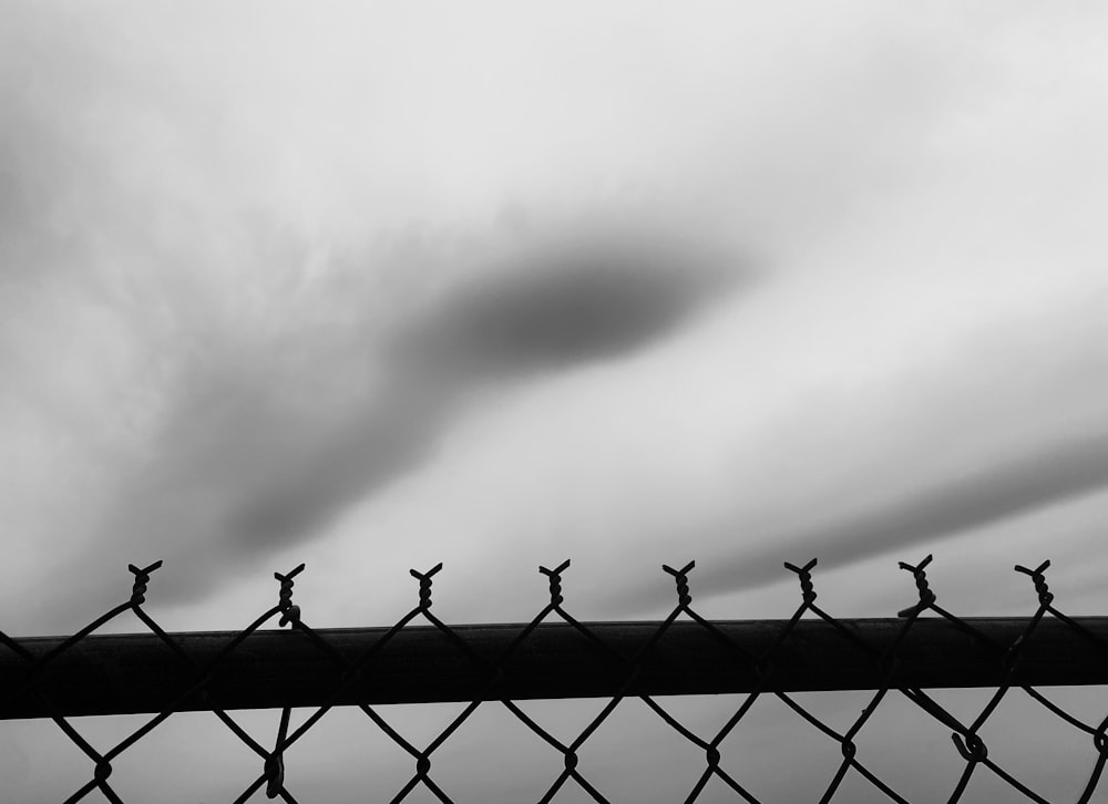 a black and white photo of a chain link fence