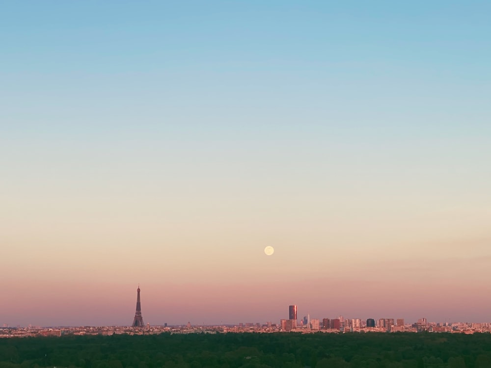 a view of a city with a full moon in the sky