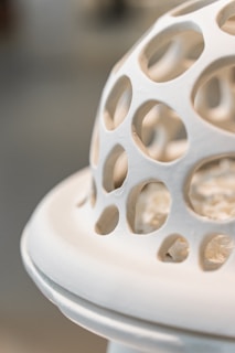 Close-up of a ceramic piece blending swirling abstract shapes with earthy textures in terracotta and white.