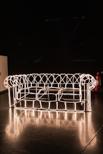 A glowing neon blue wireframe of a modern website layout on a dark background.