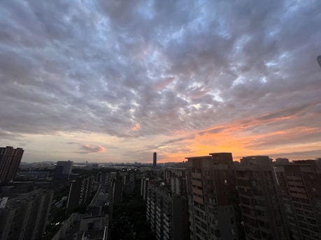 A digital rendering of a cloudy sky over a cityscape at sunset