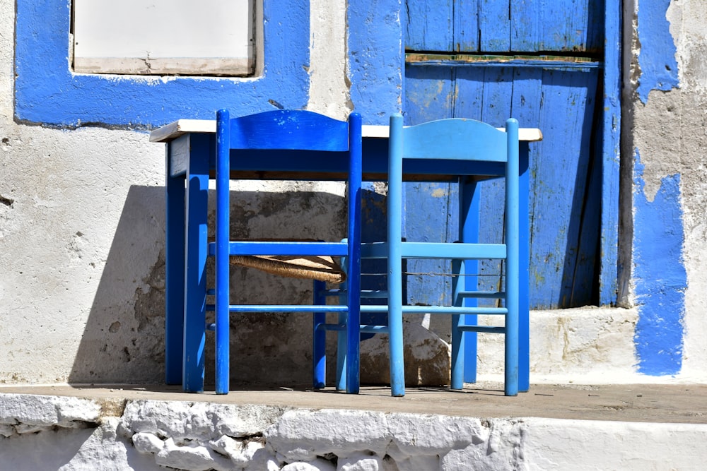 Un par de sillas azules sentadas una al lado de la otra