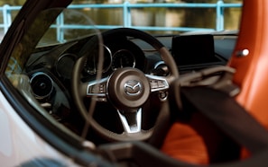 Interior shot of a Mazda MX-5 featuring custom leather seats and a personalized steering wheel