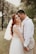 A serene outdoor pre-wedding shoot with a couple embracing in a picturesque landscape.