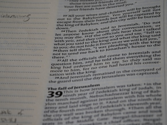A page from a religious text or Bible is shown with a section titled 'The fall of Jerusalem.' The text includes a passage about Zedekiah and Jeremiah, highlighting a conversation about secrecy and pleas for protection. The left margin has lined note spaces, one with handwritten notes including the word 'interesting.'