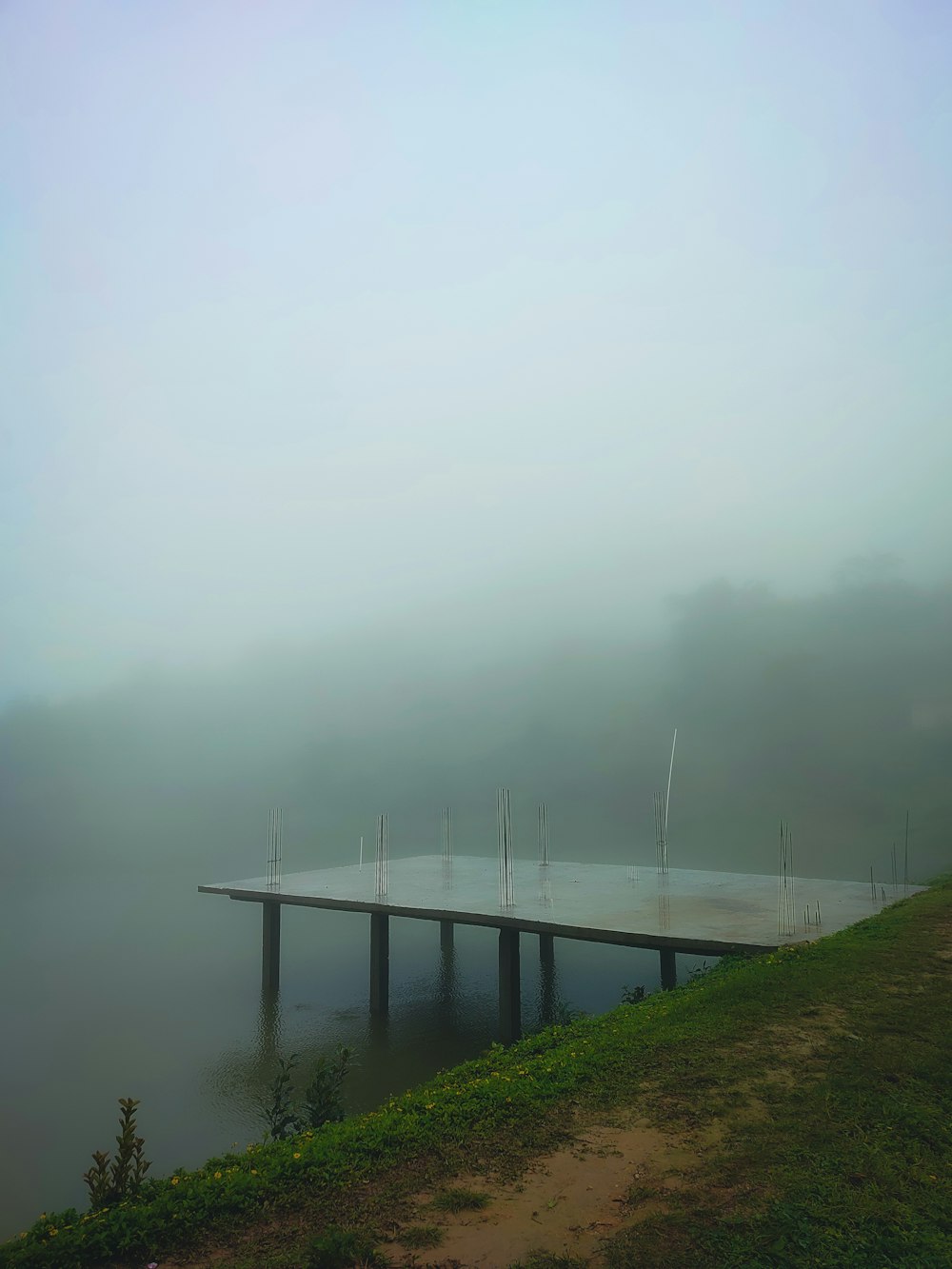 Un muelle en medio de un lago en un día de niebla