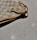Close-up of a Maison Carry handbag resting on a marble table with soft shadows.