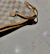 Close-up of a trendy black handbag resting on a light gray textured surface, showcasing clean lines and premium details.