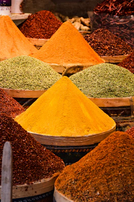 Colorful spice powders arranged in vibrant bowls at the market.
