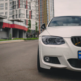 Close-up of a sleek, fuel-efficient car parked on a city street with modern buildings in the background.