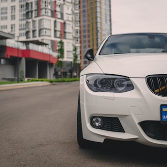 A modern car parked on a city street with a scenic backdrop.