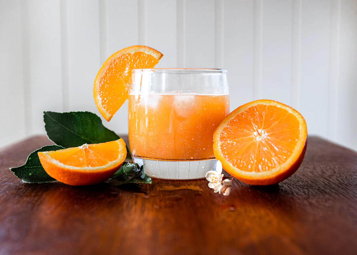 Glass of fresh orange juice with orange halves