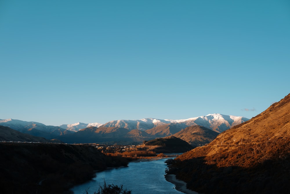 a river running through a valley surrounded by mountains