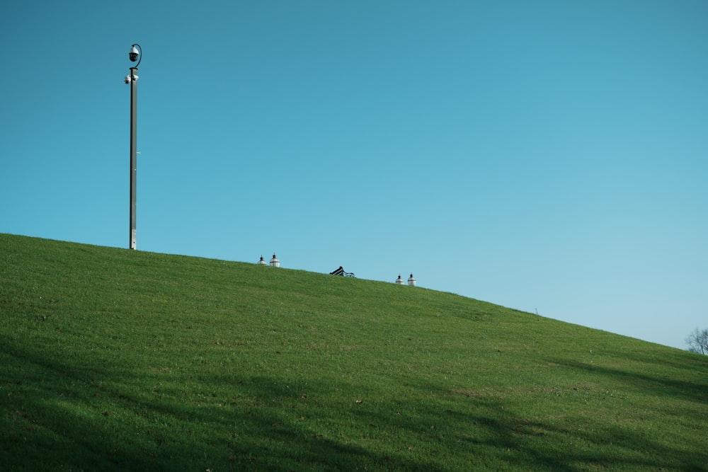 a grassy hill with a street light on top of it