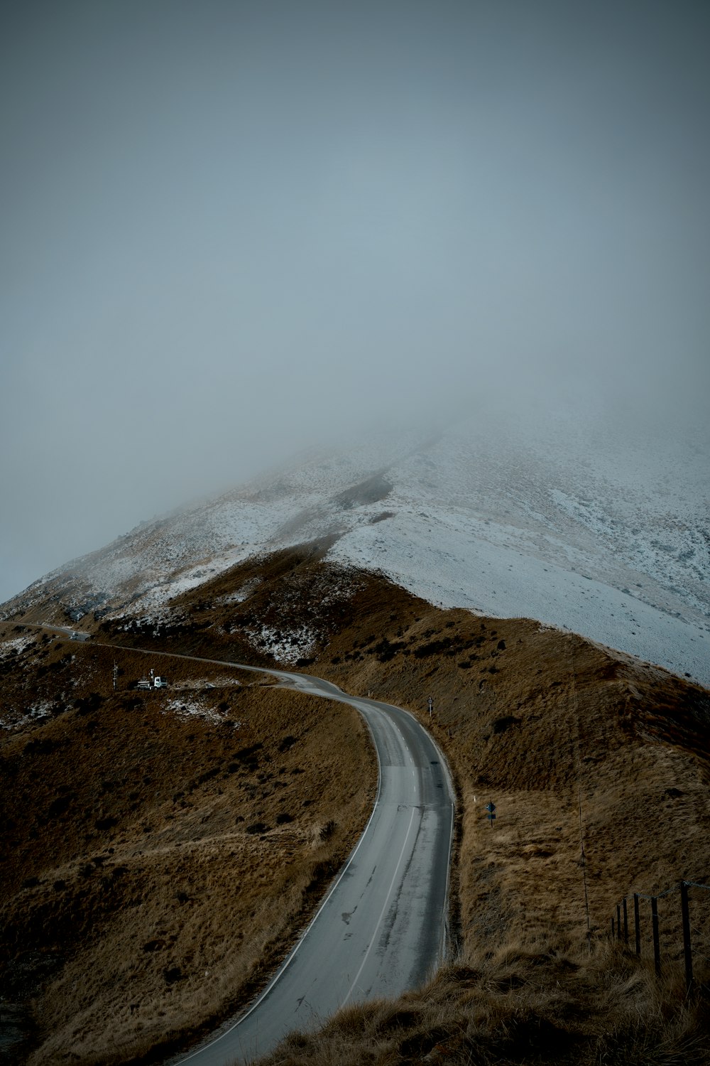 a winding road in the middle of a snow covered mountain